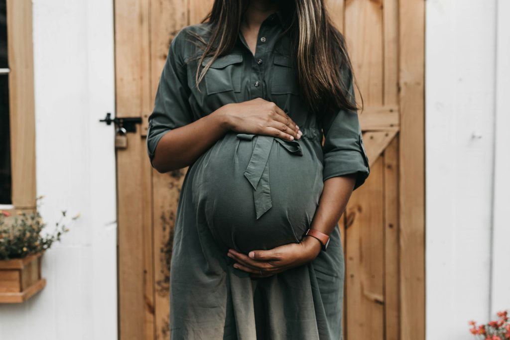 Schwange Frau in grünem Kleid